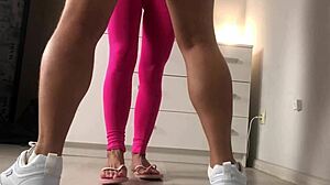 Picioarele sexy în adidași roz lovesc o minge cu încetinitorul
