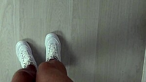 Sexede fødder i lyserøde sneakers sparker en bold i slowmotion