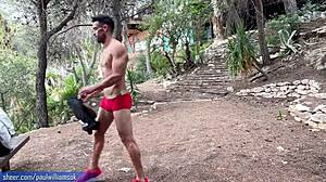 Мускулест мъж демонстрира фитнеса си, като прави голи клякания на открито